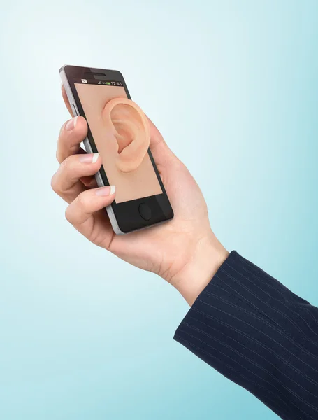Ręka trzyma telefon z ucha na ekranie. Słuchaj koncepcja. — Zdjęcie stockowe