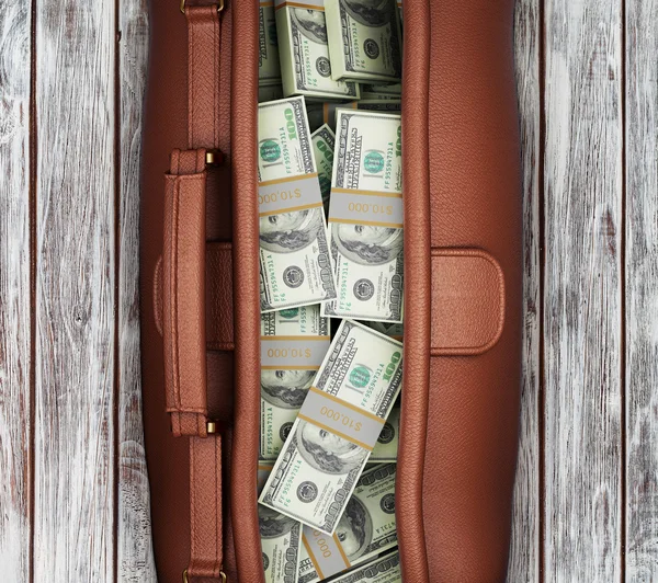 皮箱装满美元在一个木制的背景。从上面查看 — 图库照片