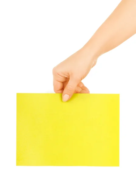 Mano sosteniendo un papel amarillo — Foto de Stock