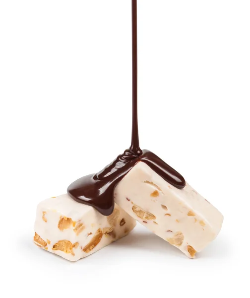 Gießen von Schokoladenbonbons Nougat und Erdnüsse auf weißem Hintergrund — Stockfoto