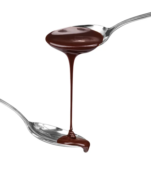 El chocolate caliente se vierte de una cuchara en una cuchara sobre un respaldo blanco —  Fotos de Stock