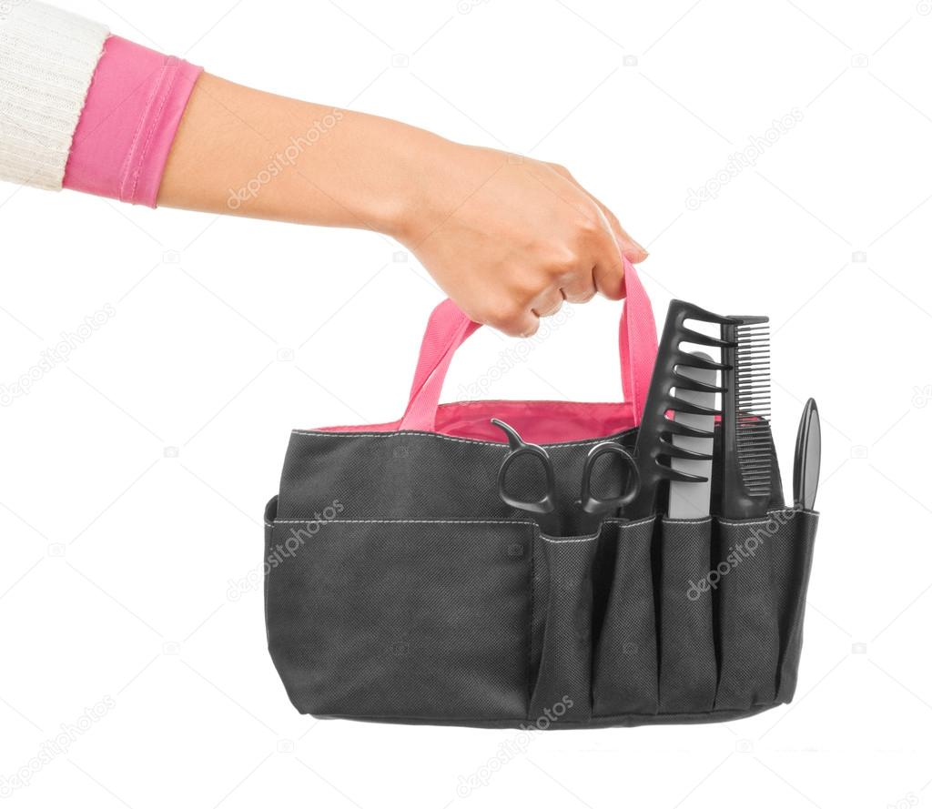 Hands holding a bag of hairdressing appliances and devices for m