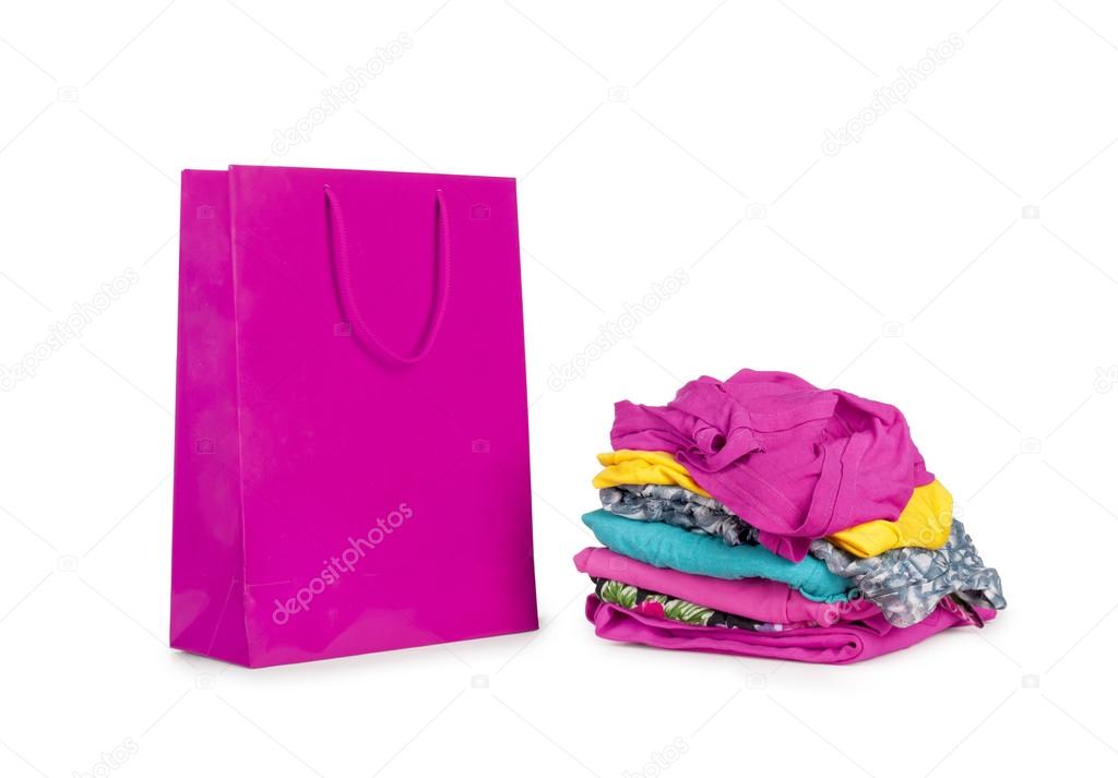 Shopping bag and a pile of clothes on white