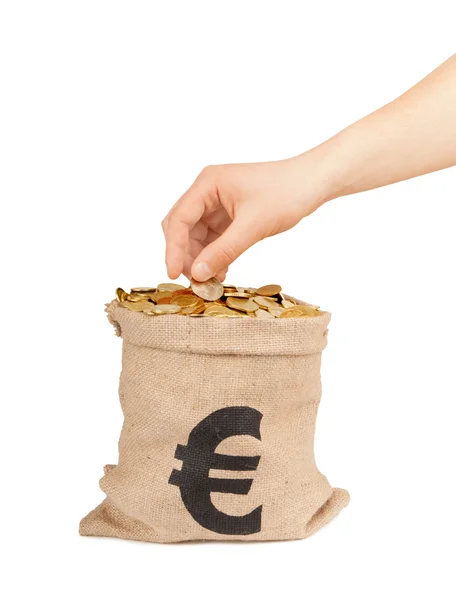 Hand lägga mynt i påse med pengar isolerad på vit — Stockfoto
