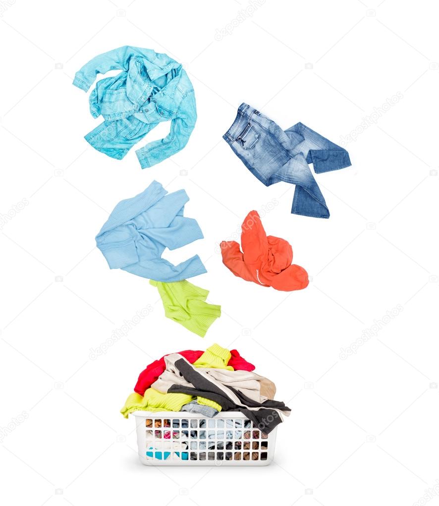 Laundry in a basket and falling clothes - isolated on a white ba