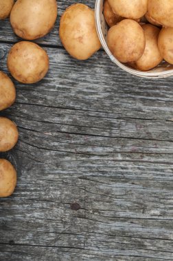 antika ahşap arka plan üzerinde bir sepette yeni patates