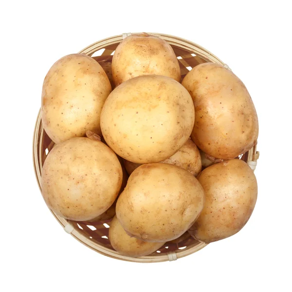 Nieuwe aardappelen in een lichte mand op een afgelegen witte achtergrond — Stockfoto