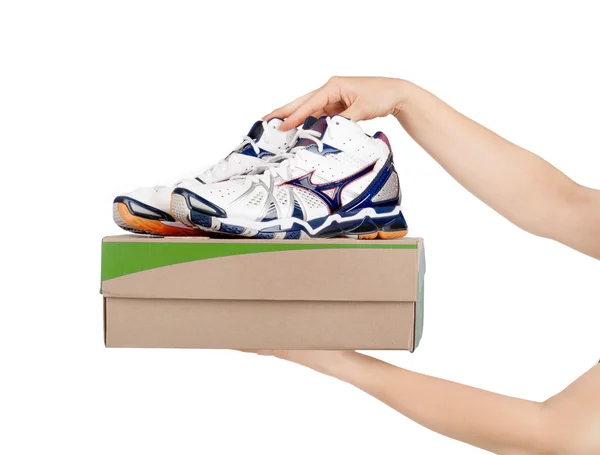 Hände, die Schuhe in einer Box halten, isoliert auf weiß — Stockfoto