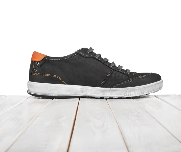 Schwarze Schuhe auf weißem Holzgrund — Stockfoto