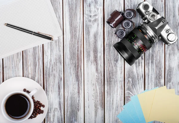 Fotocamera vintage, diario con padella e tazzina da caffè pf su tavolo in legno — Foto Stock