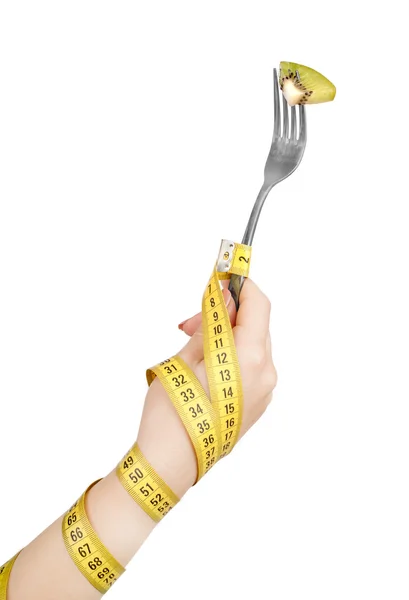 Hand wrapped with measuring tape holding a fork with kiwi — Stock Photo, Image