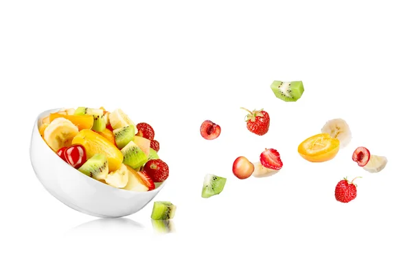Fresh mixed fruit salad falling into a bowl of salad — Stock Photo, Image