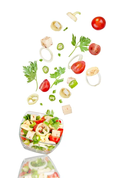 Fräsch sallad. Fallande Grönsaksblandning i skål på vita bak — Stockfoto