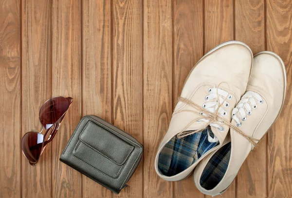 Scarpe, occhiali da sole e una borsa su uno sfondo di legno — Foto Stock