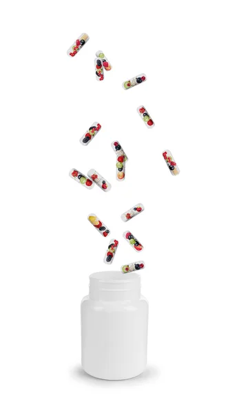 Medical capsule with berries fall into the bottle — Stock Photo, Image
