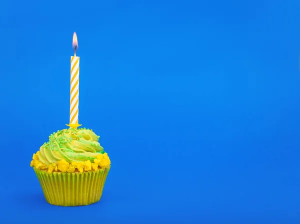 Cupcake d'anniversaire avec des bougies sur fond bleu — Photo