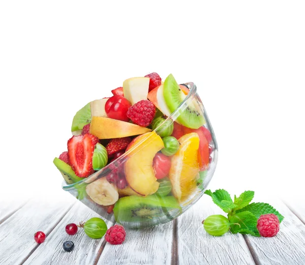 Salade de fruits dans un bol en verre table en bois blanc — Photo