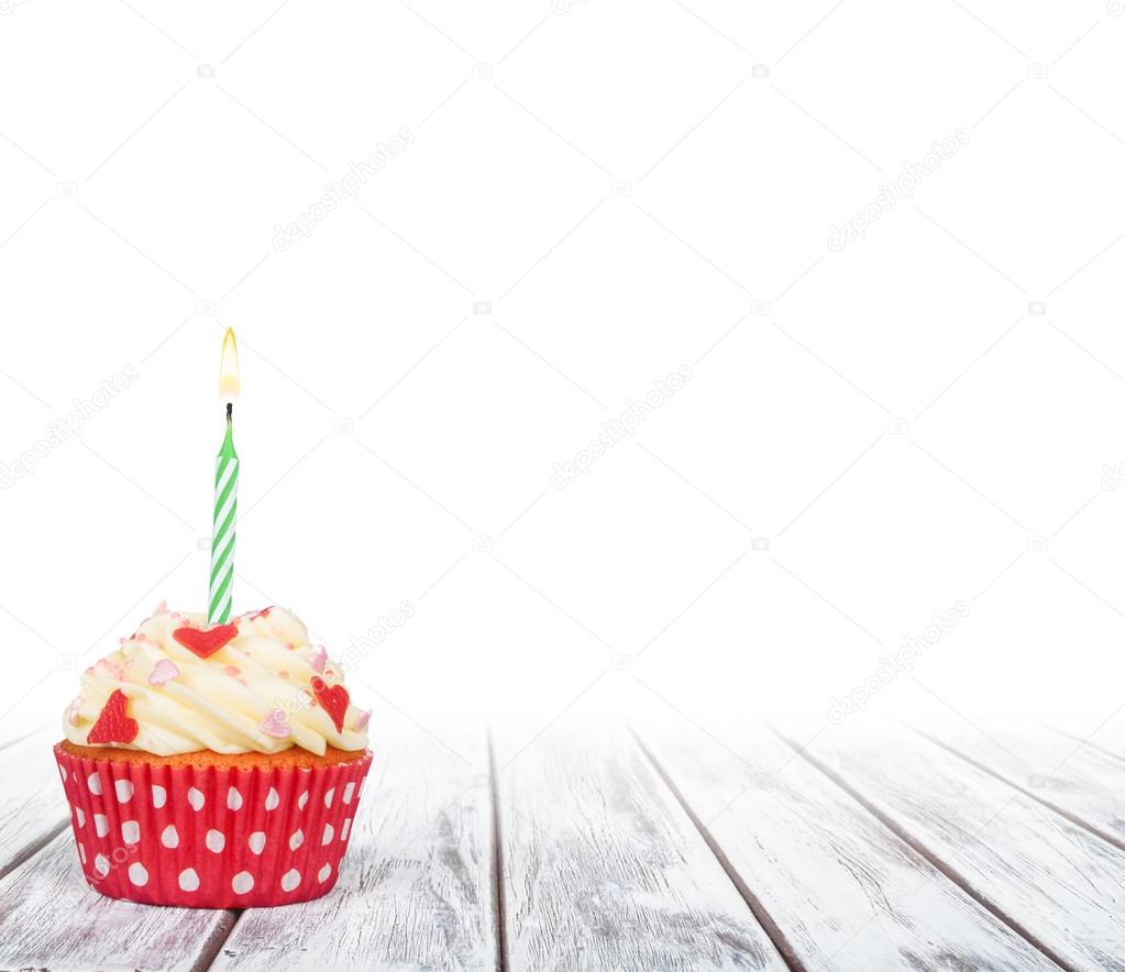 Delicious birthday cupcake on table on white background