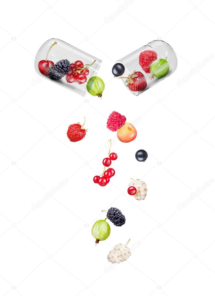 Medical capsule with berries within and falling berries isolated