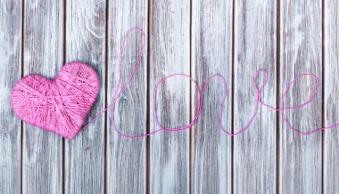 Ahşap arka plan üzerinde kalp ve word aşkın şeklinde pembe clew