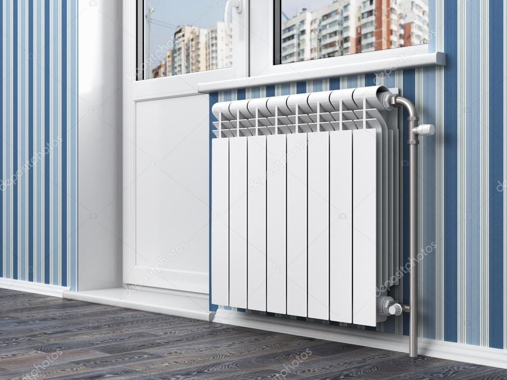White radiator with thermostat in the apartment