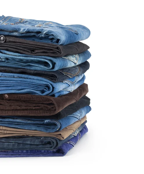 Haufen Jeans isoliert auf weißem Hintergrund — Stockfoto