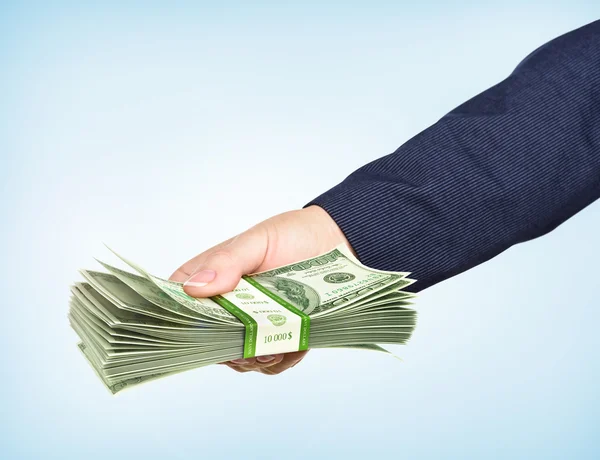 Hand houdt een pack van dollar op blauwe achtergrond. Neem het geld. — Stockfoto