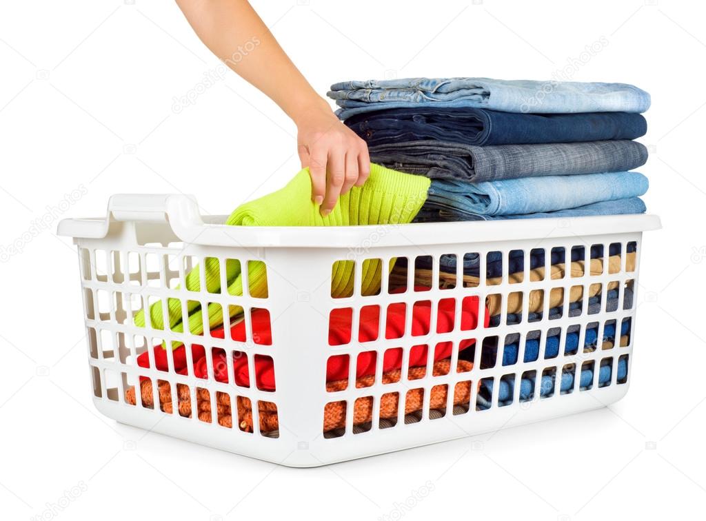 Laundry basket with folded clothes over white background