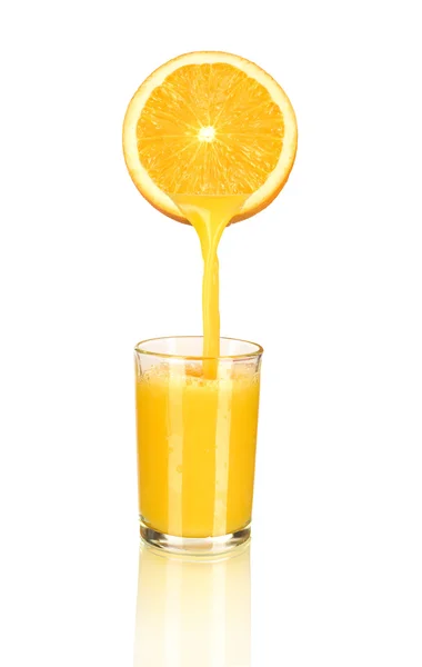 Orange juice pouring in glass from half of orange isolated on wh — Stock Photo, Image