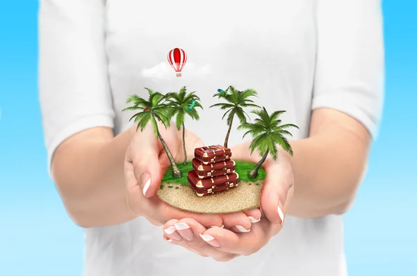 Small fantastic island with palms and suitcase in women's hands. — Stock Photo, Image