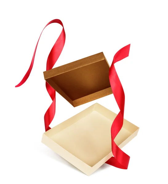 Empty gift box with red ribbon falling on an isolated white back — Stock Photo, Image