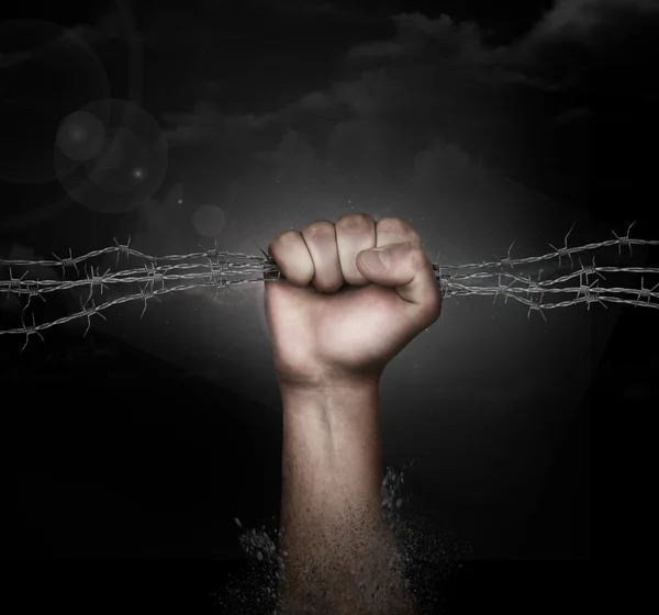 Dirty hand grabbing a barbed wire on black background — Stock Photo, Image