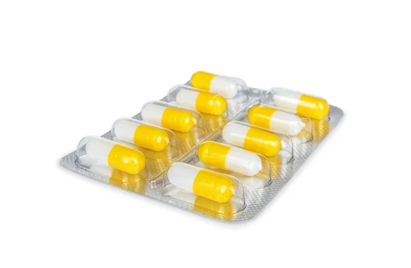 Jasne żółte kapsułki w pakiet na białym tle — Zdjęcie stockowe