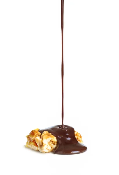 Geschmolzene Schokolade wird auf Nüsse Karamell gegossen — Stockfoto