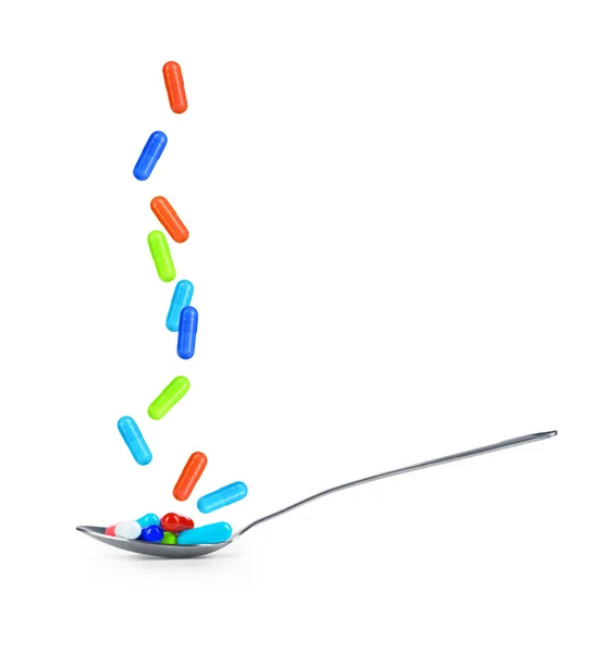 Spoon full of pills on a white background — Stock Photo, Image