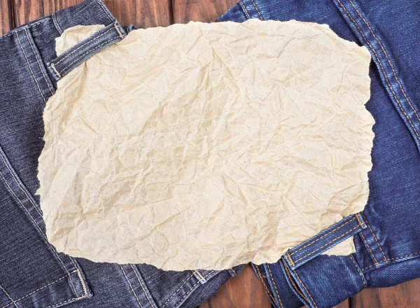 A sheet of paper on the jeans — Stock Photo, Image