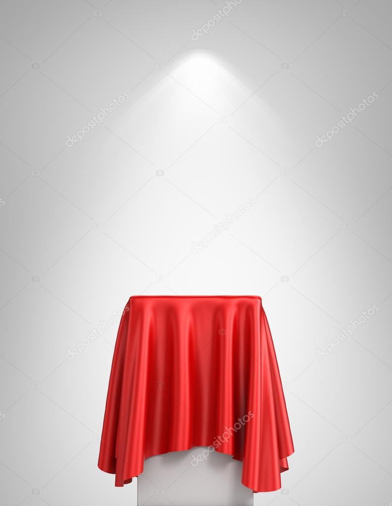 Presentation pedestal covered with a red silk cloth in front of 