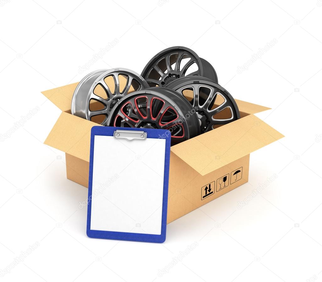 Automobile rims in an open cardboard box with a folder for docum