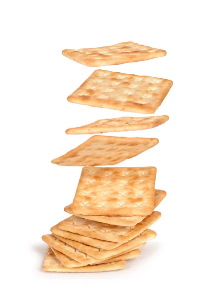 De krakers vallen op de stapel van vierkante crackers geïsoleerd op wh — Stockfoto