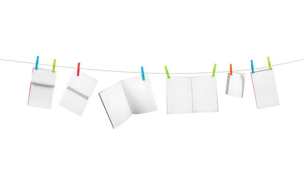 Exercise books on the rope isolated on white — Stock Photo, Image