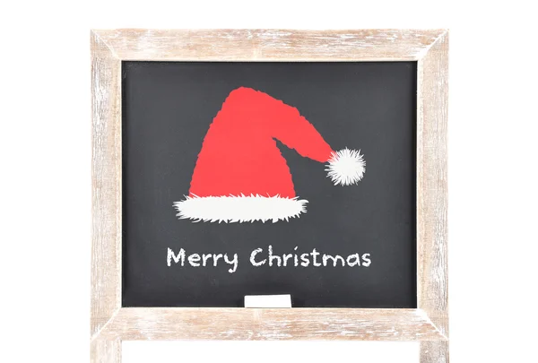 Christmas greetings with Santas hat on blackboard — Stock Photo, Image