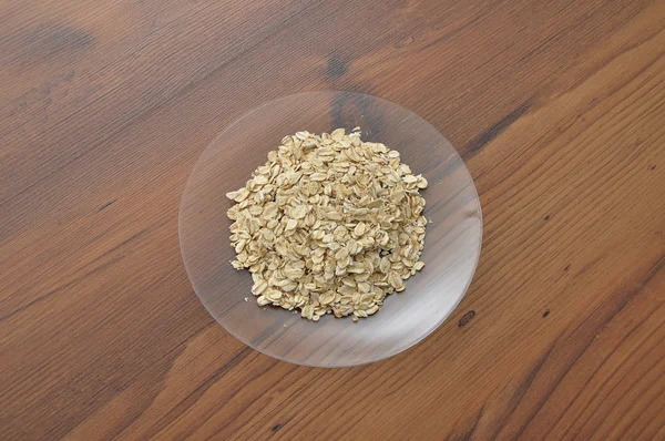 Plate of glass with oat flakes — Stock Photo, Image