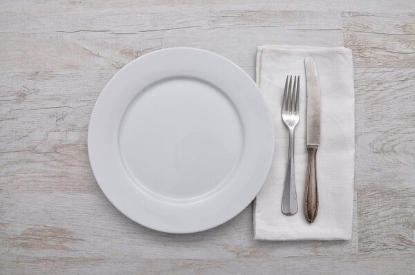 Plate, cutlery and cloth on wood