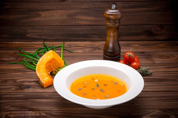 Soupe de citrouille aux légumes et assaisonnement sur fond de bois — Photo