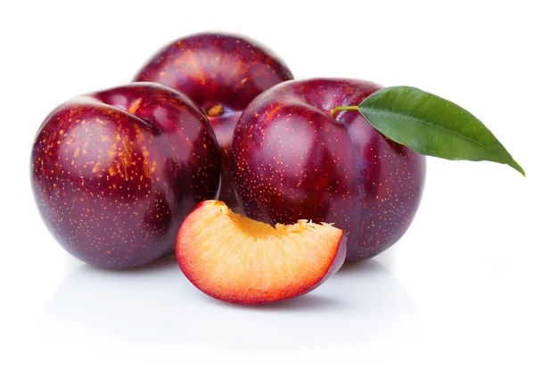 Ripe purple plum fruits with green leaves isolated on white — Stock Photo, Image