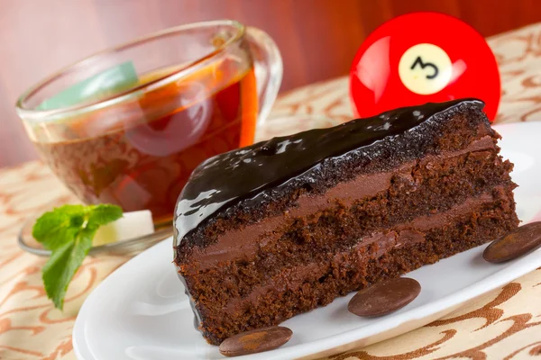 Porción de pastel de chocolate y taza de té con menta fresca — Foto de Stock