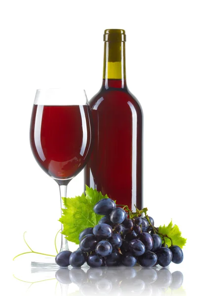 Pohár vörös bor a palack és elszigetelt érett szőlő — Stock Fotó