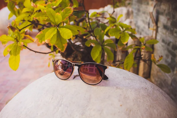 Gafas de sol se encuentran en piedra — Foto de Stock