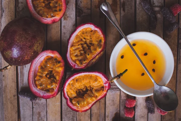 Passion fruit pulp and seed board, spoon, candied fruit, plate w — Stock Photo, Image