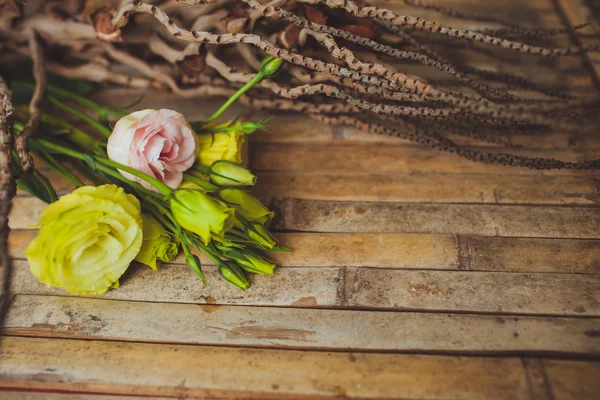 Eustoma a růže ležící na dřevěném prkénku — Stock fotografie
